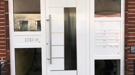 haustuer-weiß-mit-zwei-seitenteilen-mit-briefkastenanlage-und-klingeln-bei-mehrfamilienhaus